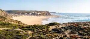 Vue panoramique de la plage de Praia de Monte Clérigo, marée basse avec la municipalité de Aljezur, journée ensoleillée de mai, Aljezur, Algarve, Portugal